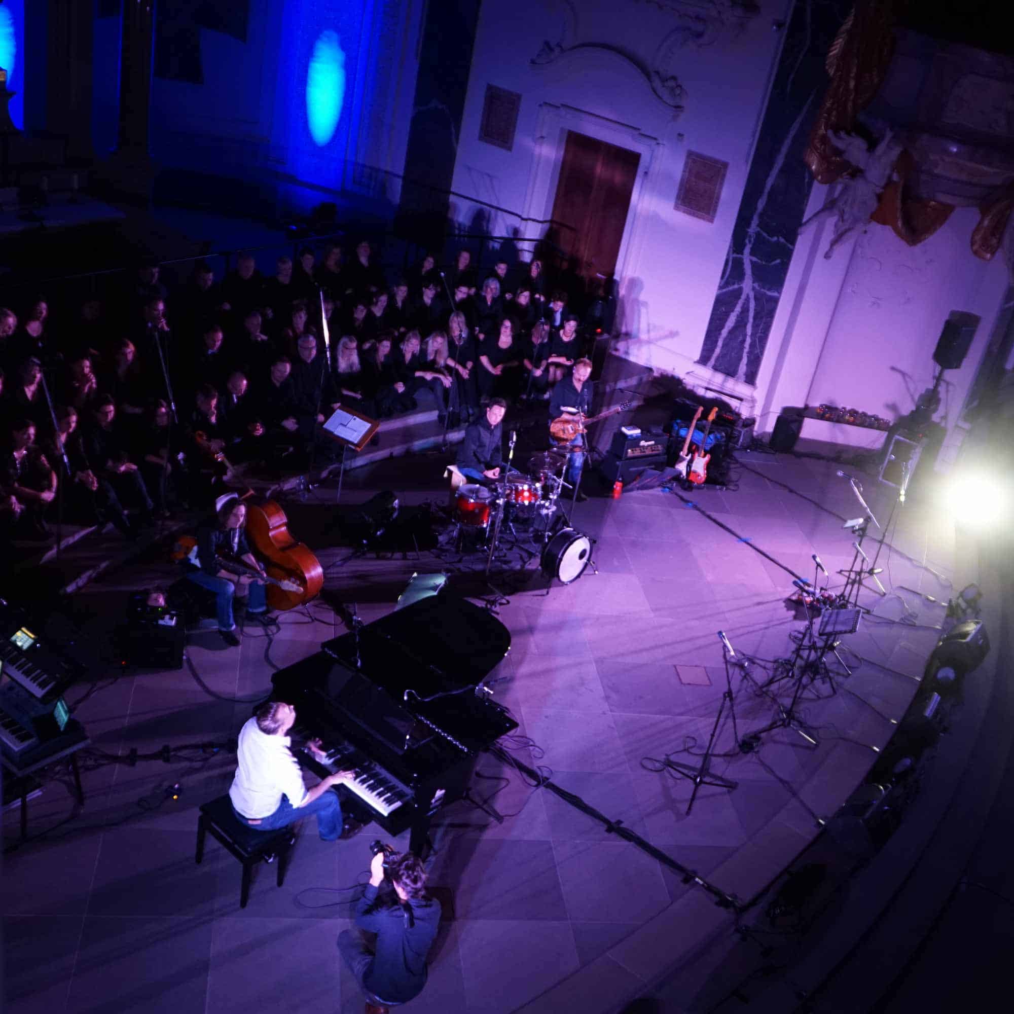 Bühne mit Band und Flügel von oben, lila Licht